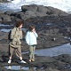 Mum with a child walking along the beach