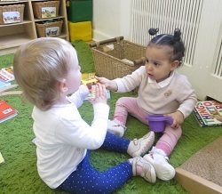 Toddler sharing a toy