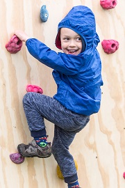 Child enjoys climbing wall at the Geronimo Festival