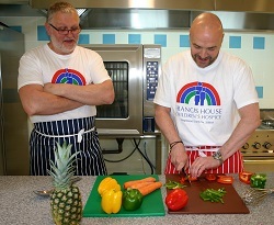 Simon Rimmer demonstrates vegetable preparation skills to Dean Jenkins, chef of Francis House.