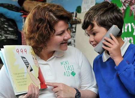 King's Junior and Infant Division pupil learns emergency phone numbers with the help from Mini First Aid representative