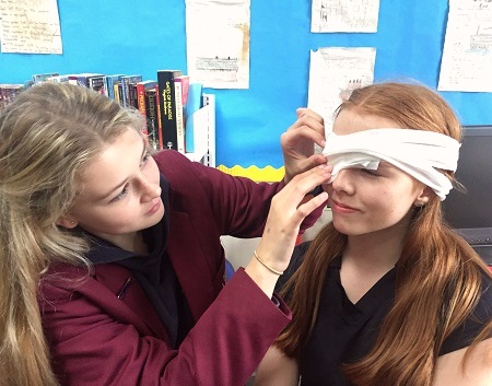 Pupils practicing to apply the bandages at the first aid classes at Hulme Hall Grammar School