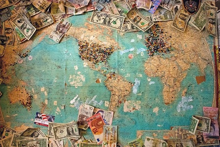 Map with different destinations and money in local currencies | Tips in different countries | photo Christine Roy, Unsplash