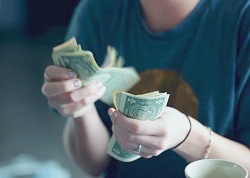 Traveller counting money | Proper tips in different countries | photo: Sharon Mccutcheon, Unsplash