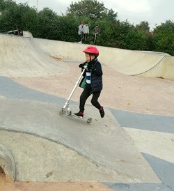 Child riding his scooter on the ramp