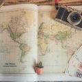 Travel accessories: world map compass, money, Photo by Chris-Lawton, Unsplash