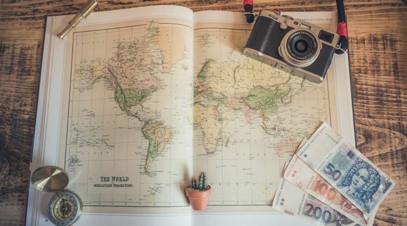 Travel accessories: world map compass, money, Photo by Chris-Lawton, Unsplash