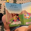 A child reading The Adventures of Lillicorn in WooWoo Land