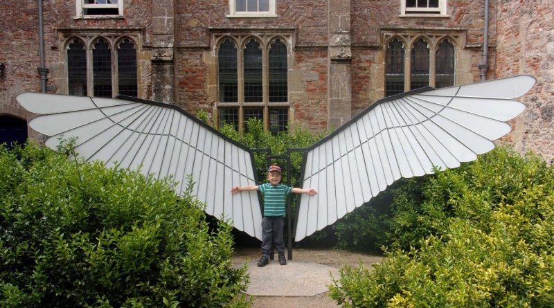 Boy pretends this sculpture is his wings
