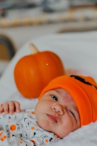 Baby with a pumpkin by Omar Lopez from unsplash