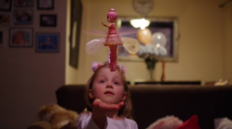 Girl is watching a flying fairy toy
