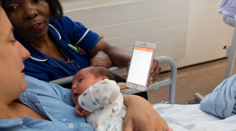 New mum is shown Mum & Baby app by a midwife