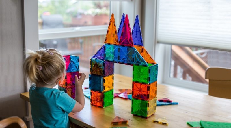 Girl playing with Magna-Tiles building blocks