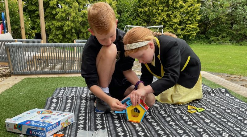 A boy and a girl playing with GeoMag Supercolour Panels play set