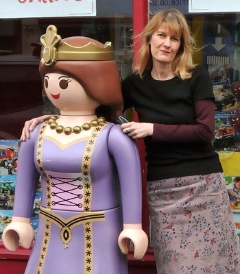 Amanda Alexander with giant Playmobil figurine at the doors of her Giddy Goat shop