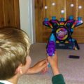 Boy playing Electronic Arcade Hover Shot, an Ambassador Games