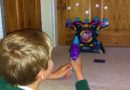 Boy playing Electronic Arcade Hover Shot, an Ambassador Games
