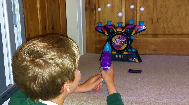 Boy playing Electronic Arcade Hover Shot, an Ambassador Games
