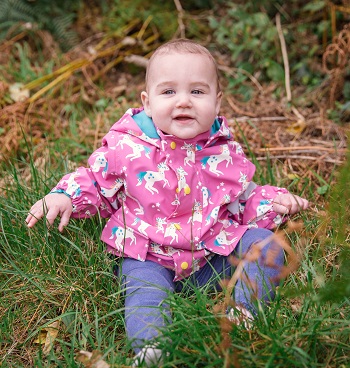 Baby girl in unicorn raincoat by Blade and Rose