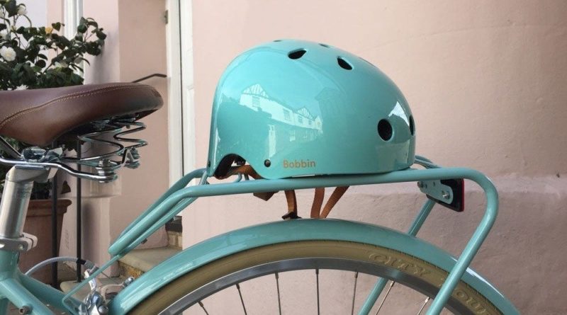 Bobbin's green Starling bike helmet on a bicycle seat.