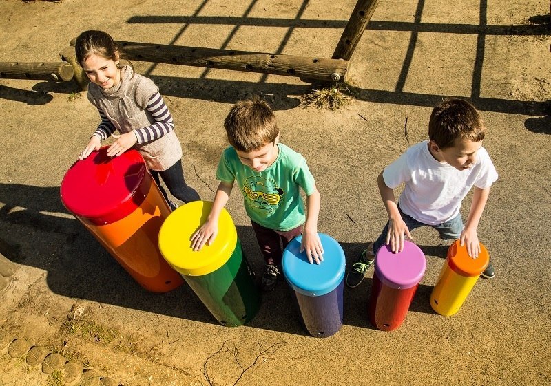 Children having fun playing outdoor drums
