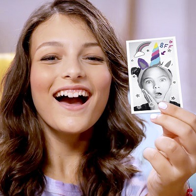 Girl with a picture that was done on a instant pocket printer.