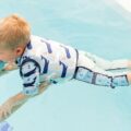 Boy in a water wearing Splash About Moby print swim vest
