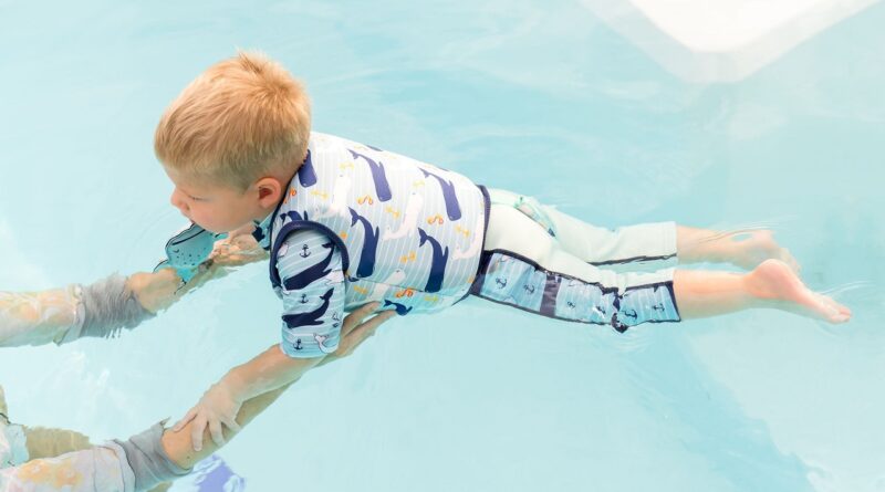 Boy in a water wearing Splash About Moby print swim vest