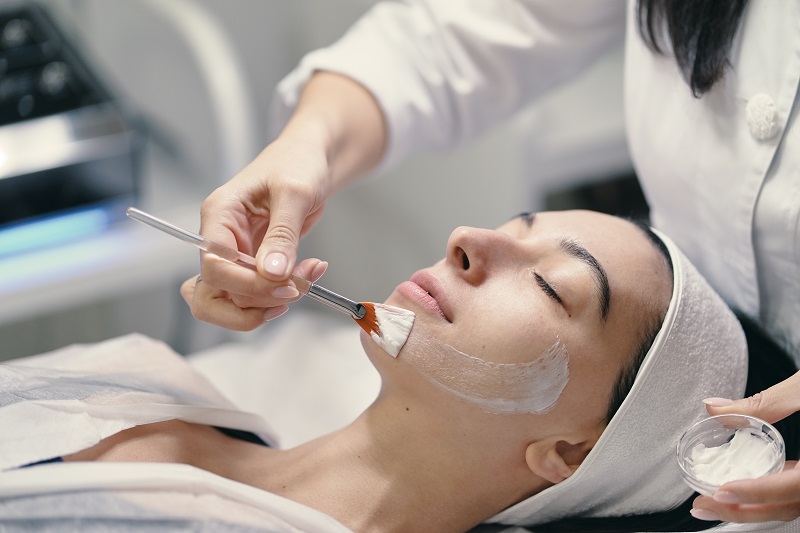 Aesthetic practitioner apply chemical peel to a woman's face