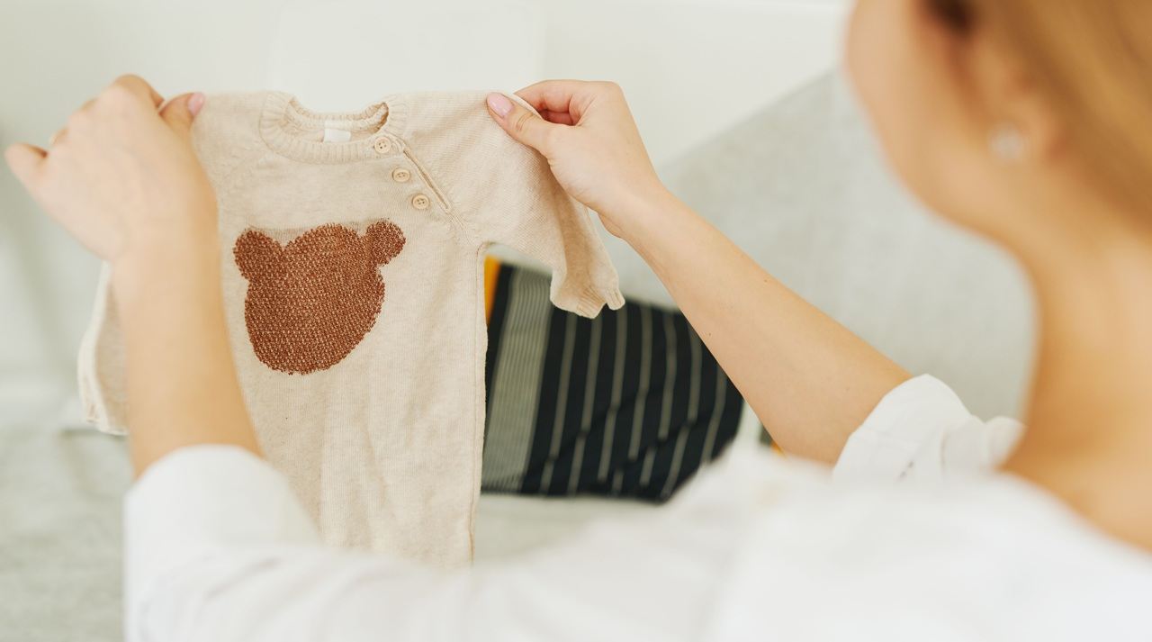Woman looking at baby's t-shirt