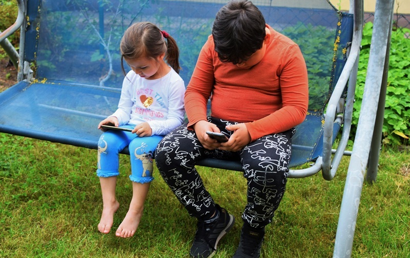 A boy and a girl with their phones