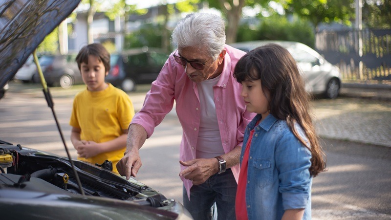 Grandad and children next to the car