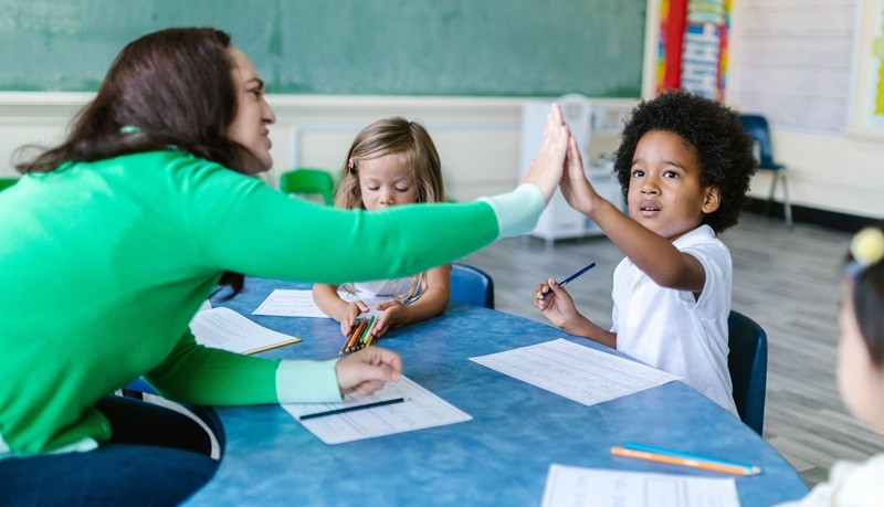 Teacher and children sitting at the desk