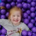 A girl is having fun in the sea of balls at Inflata Nation, Trafford