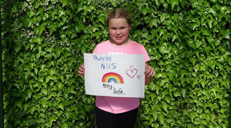 Girl holds Thank you NHS rainbow