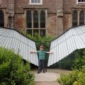 Boy pretends this sculpture is his wings