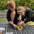 A boy and a girl playing with GeoMag Supercolour Panels play set