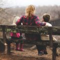 Mum with 2 kids on a bench, photo by Benjamin Manleyfrom