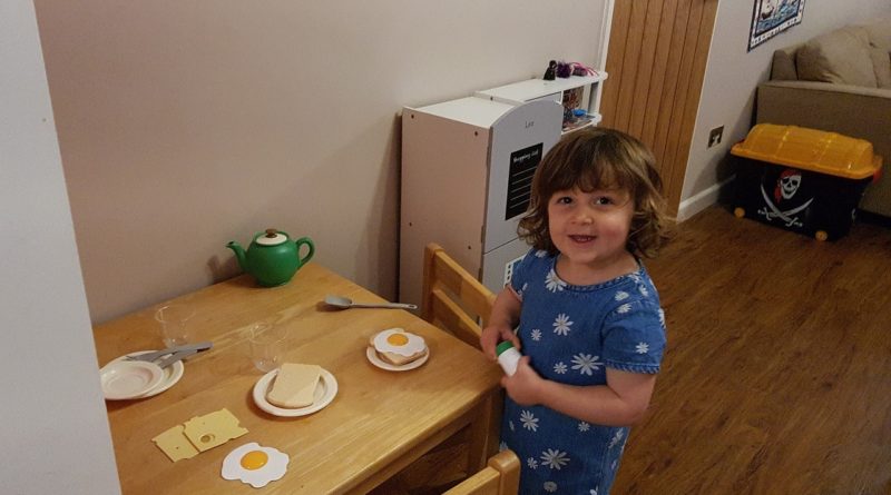 Girl with a breakfast toy set