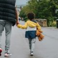 A parent and a child walking along the road | photo by Anete Lusina