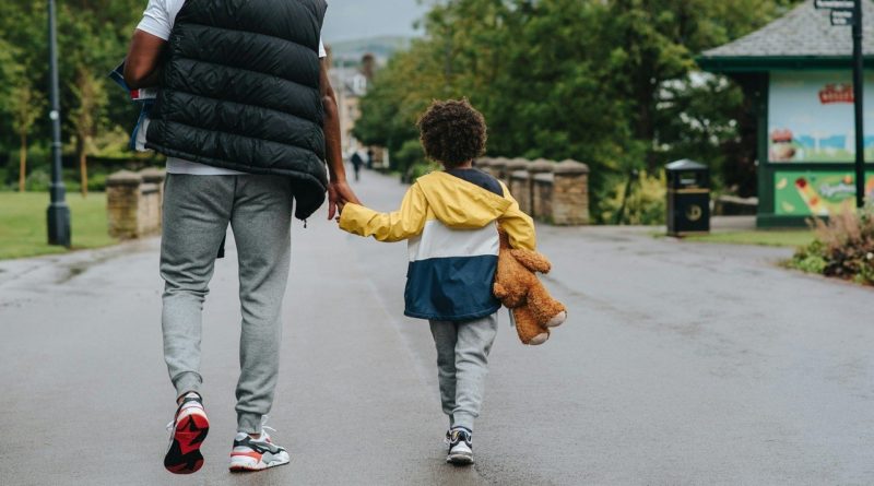 A parent and a child walking along the road | photo by Anete Lusina