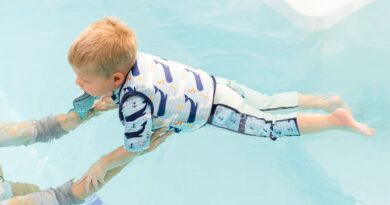 Boy in a water wearing Splash About Moby print swim vest