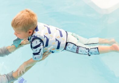 Boy in a water wearing Splash About Moby print swim vest