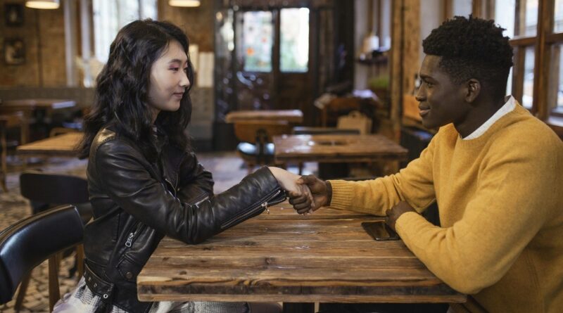 Young couple at the table holding hands