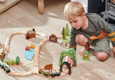 Boy playing with Tender Leaf Toys wild pines train set