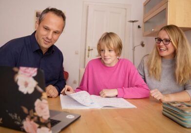 A girl with her parents in front of the computer