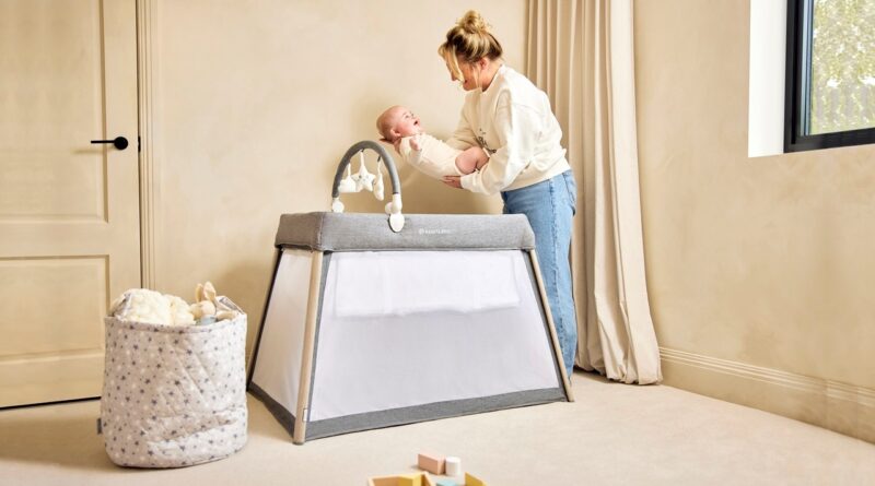 IBLI Scout 3 in 1 Travel Crib, Cot and Playpen | Mother putting a baby in the cot